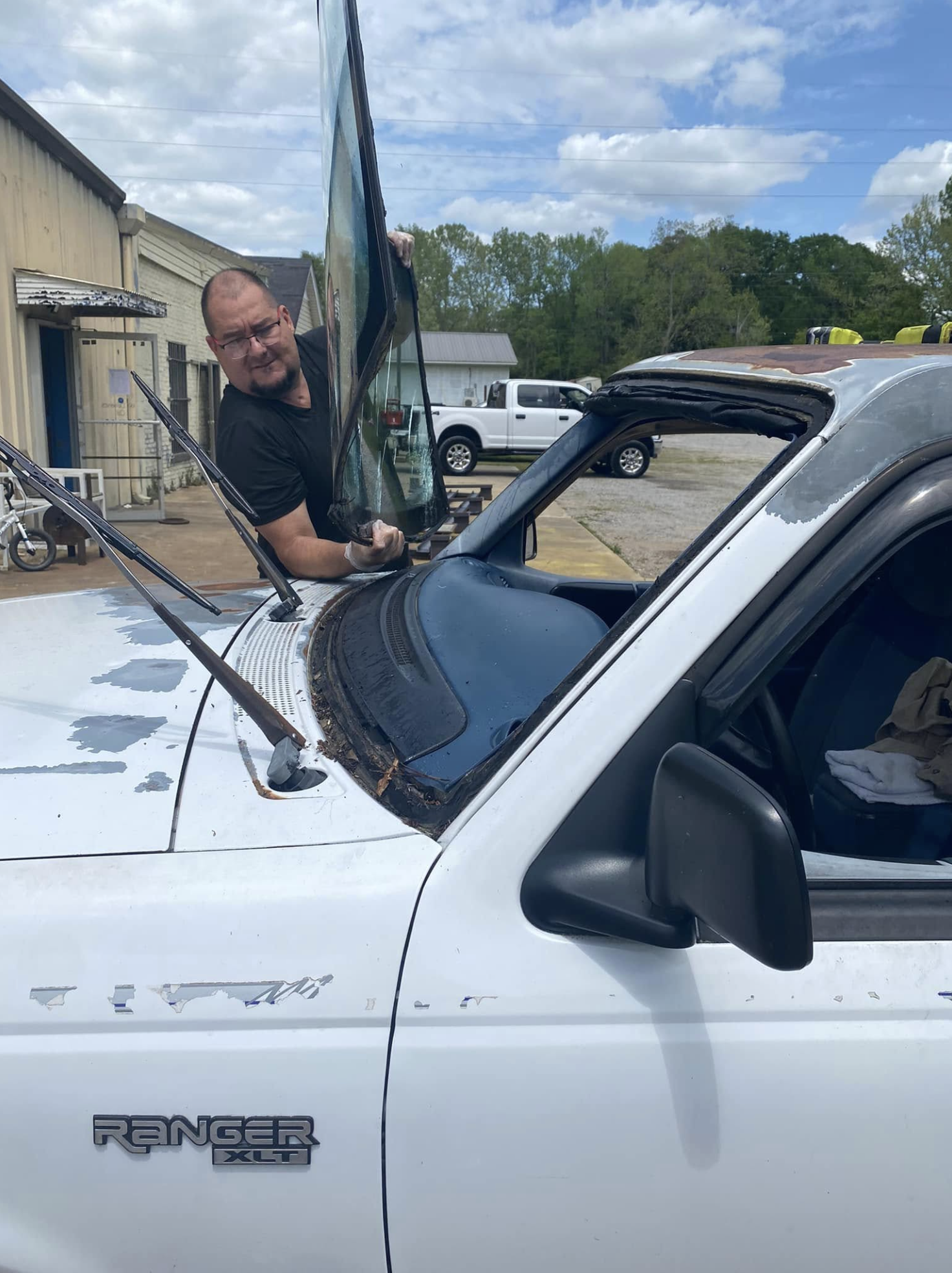 Yovany standing in front of his auto glass shop